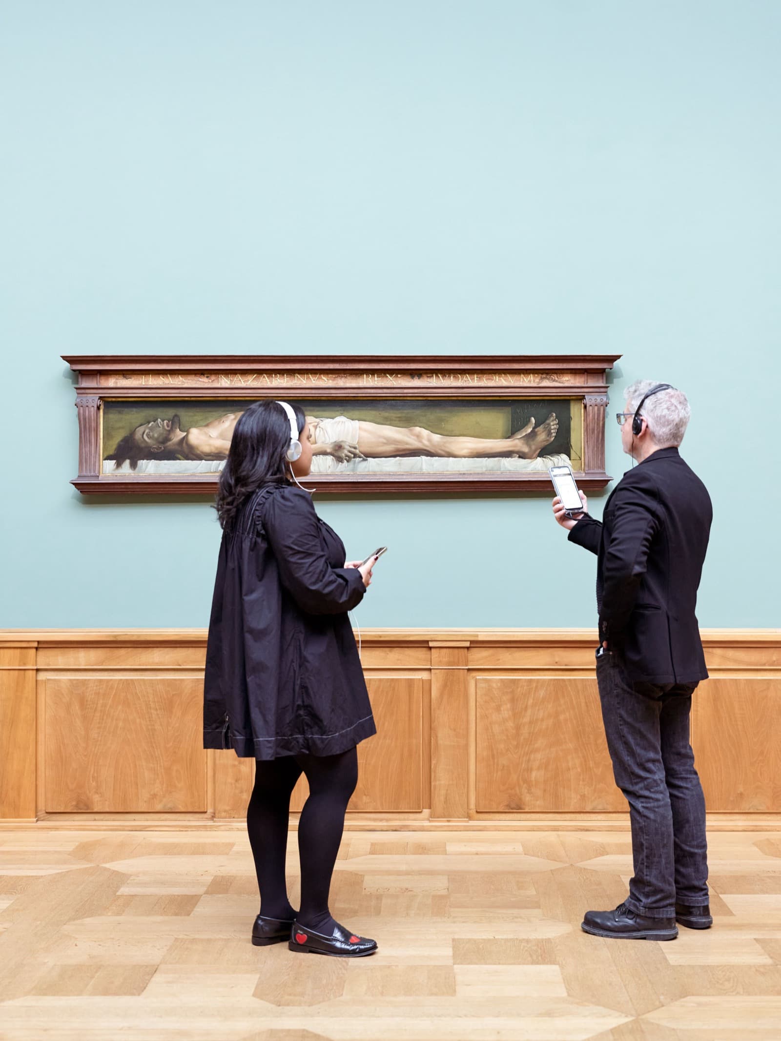 Zwei Besucher mit Kopfhörern vor einem Gemälde im Kunstmuseum Basel